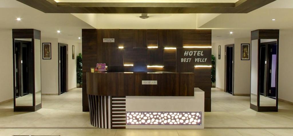 a lobby with a counter in the middle of a building at Hotel Best Velly in Gandhinagar