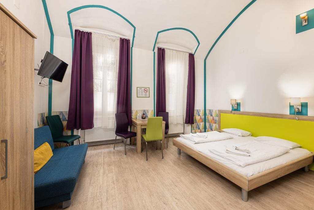 um quarto com uma cama, uma mesa e cadeiras em Amber Gardenview Studios Downtown em Budapeste