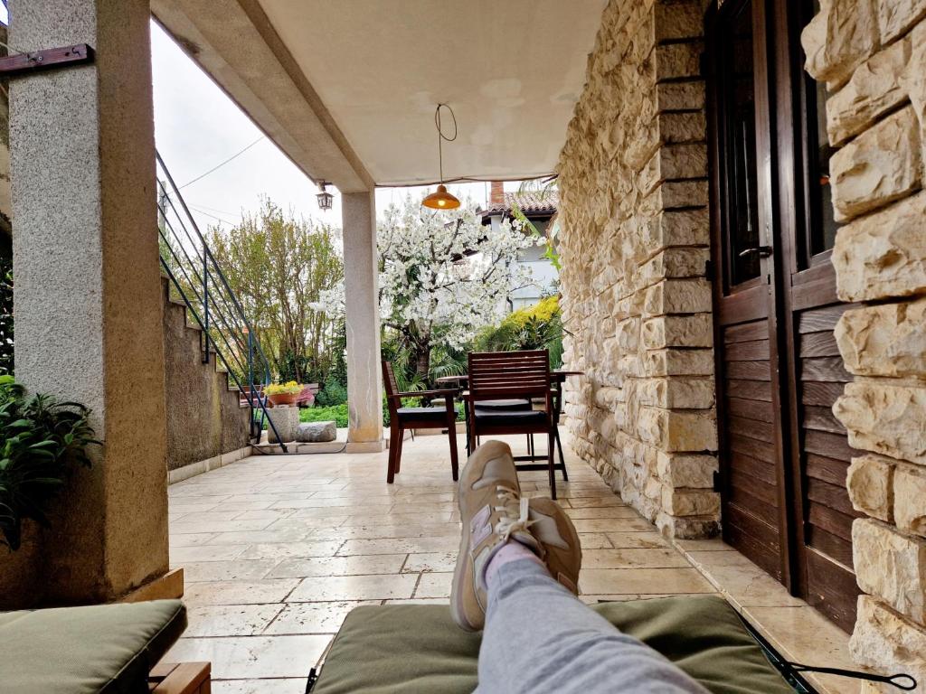 a person with their feet up on the porch of a house at Villa Mihaela Porec in Poreč