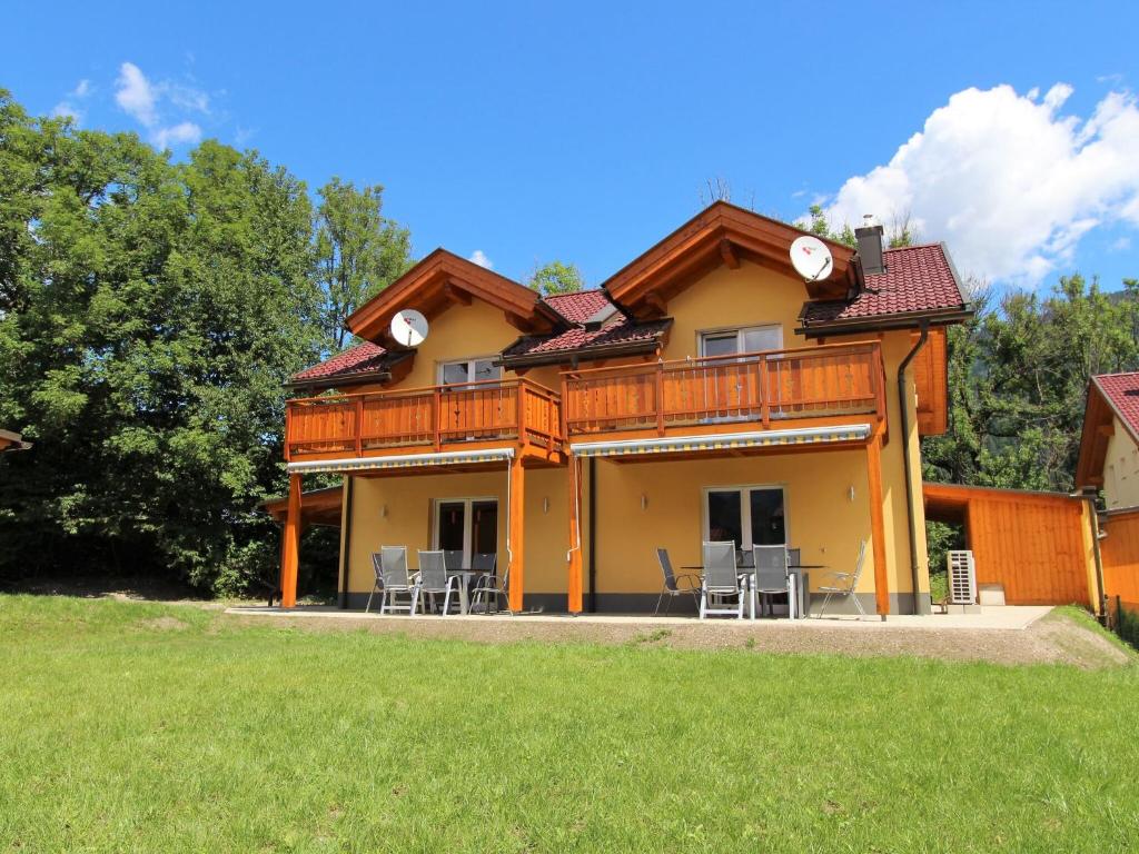 ein großes Haus mit Stühlen und einem Dach in der Unterkunft Luxurious Chalet in K tschach Mauthen near Ski Area in Kötschach