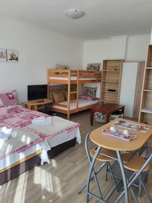 Habitación con 2 camas, mesa y cama en Renáta Apartman en Nyíregyháza