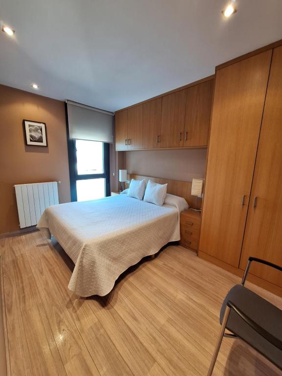 a bedroom with a large bed and wooden cabinets at Apartamento Enol in Cangas de Onís