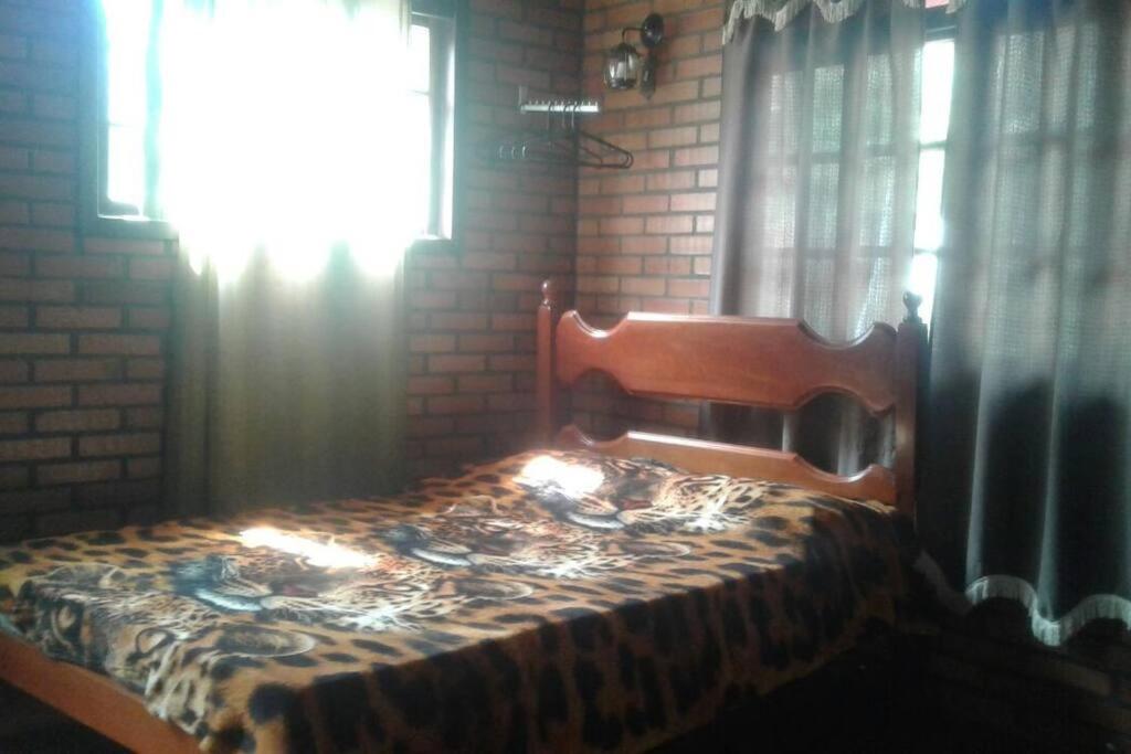 Recanto beira rio - Sao Pedro da serra. في نوفا فريبورغو: غرفة نوم عليها سرير وبطانية
