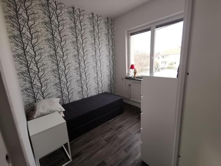 a small bedroom with a bed and a window at Fin lägenhet i närheten av stan och lasarettet in Motala