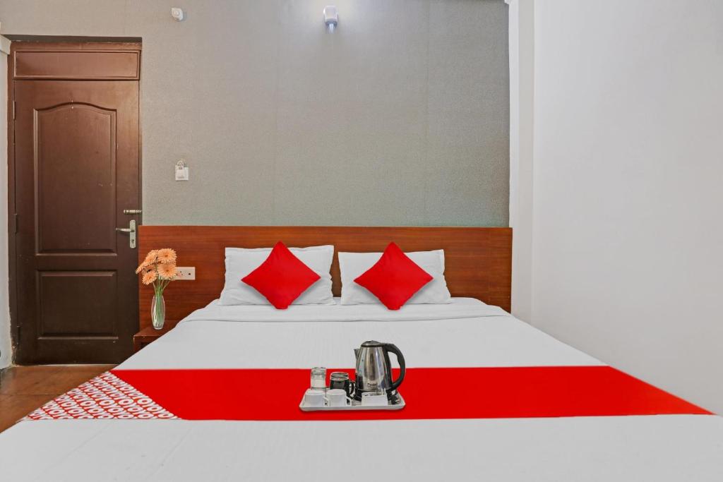 a hotel room with a bed with red pillows at OYO Hotel Jayam Ooty Residency in Ooty