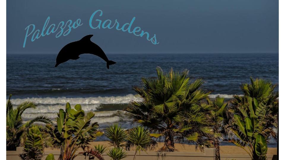 een dolfijn die over een strand met palmbomen vliegt bij Palazzo Gardens -Self catering Guesthouse in Swakopmund