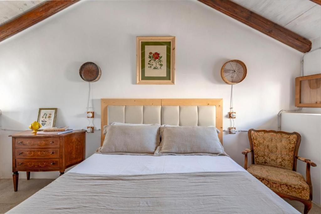 1 dormitorio con 1 cama, vestidor y silla en Masseria Caretti Grande, en Casalabate