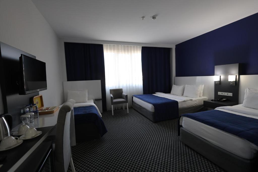 エディルネにあるCavit Duvan Prestige Hotelのベッド2台とテレビが備わるホテルルームです。