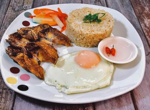 a plate of food with a fried egg and bread at DGA Traveler's Inn in Coron