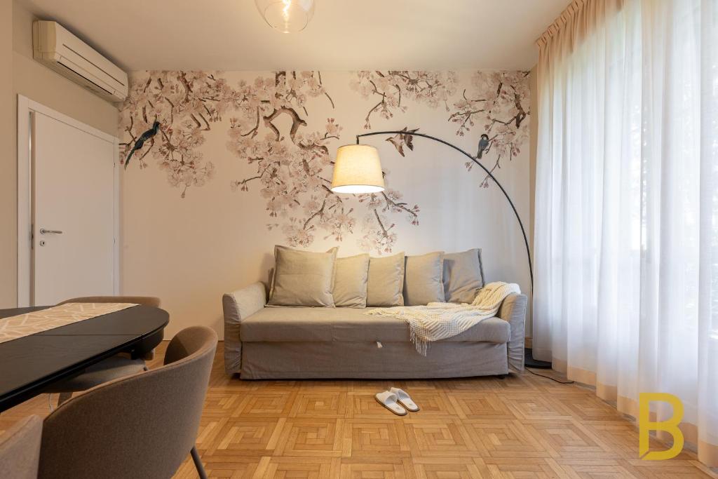 ミラノにあるBePlace Apartments in Fieraのリビングルーム(ソファ、ランプ付)