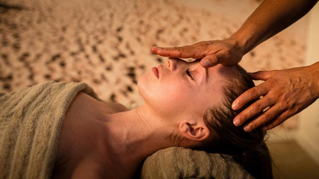 a woman getting a haircut at a hair salon at Kyriad Prestige Residence & Spa Cabourg-Dives-sur-Mer in Dives-sur-Mer
