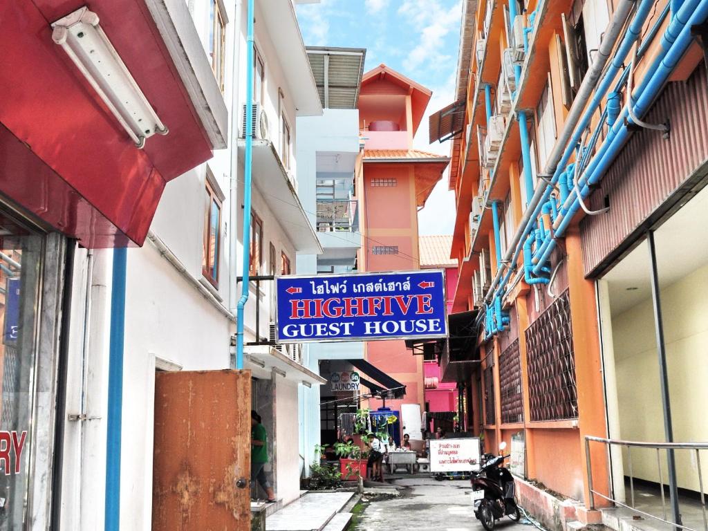 una strada con segnaletica sul lato degli edifici di Highfive Guest House a Centro di Pattaya