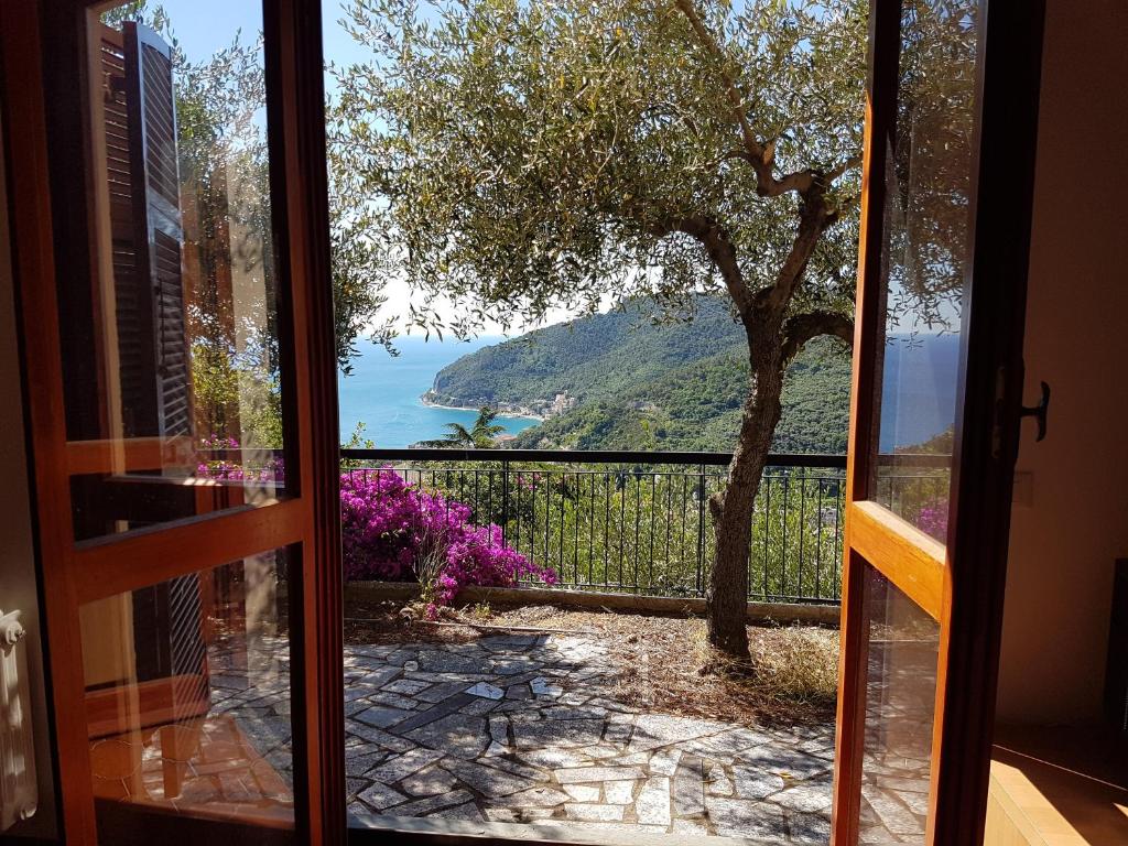 a door to a balcony with a view of the ocean at Villino Bougainvillea in Voze