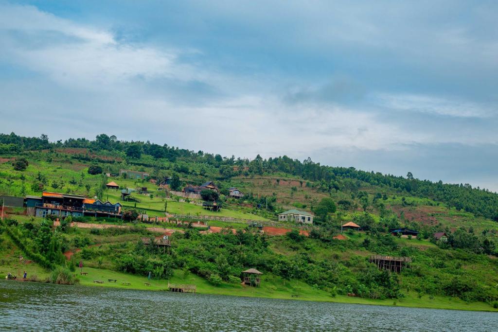 a train on a hill next to a body of water at GOOD MOOD BEACH RESORT LTD in Rwamagana