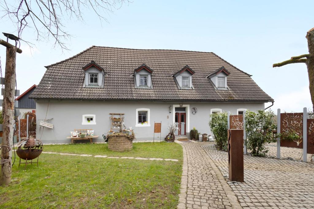 a large white house with a brick driveway at Ferienhaus Annodazumol in Waischenfeld