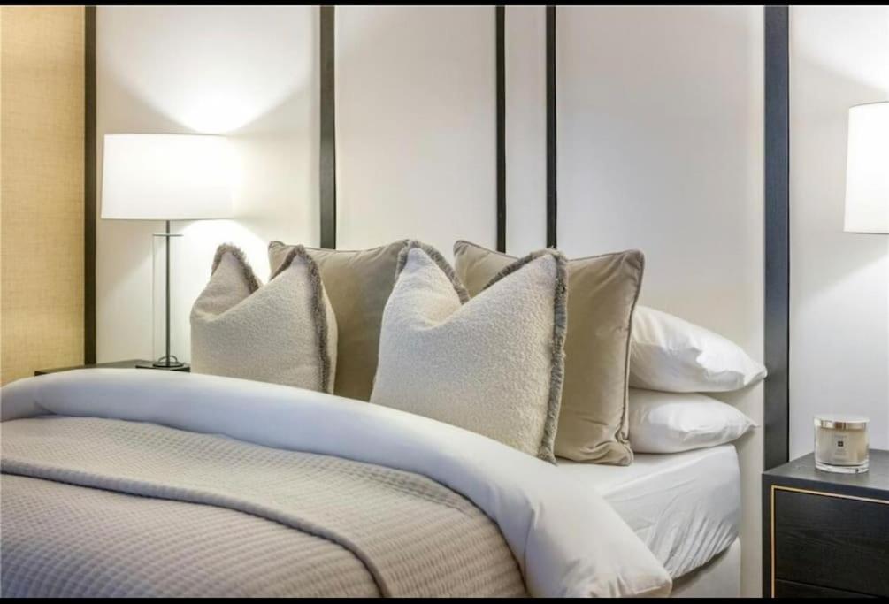 a white bed with white pillows on it at Central Based Snug Apartment! Private Parking in the heart of Bristol in Bristol