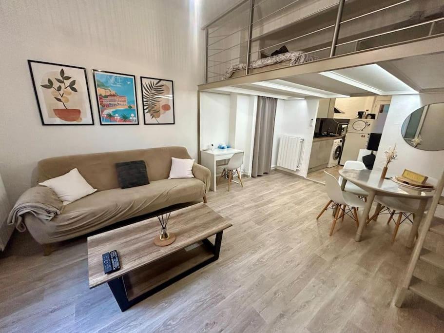 un salon avec un canapé et une table dans l'établissement Charmant studio mezzanine au cœur de Nice, à Nice