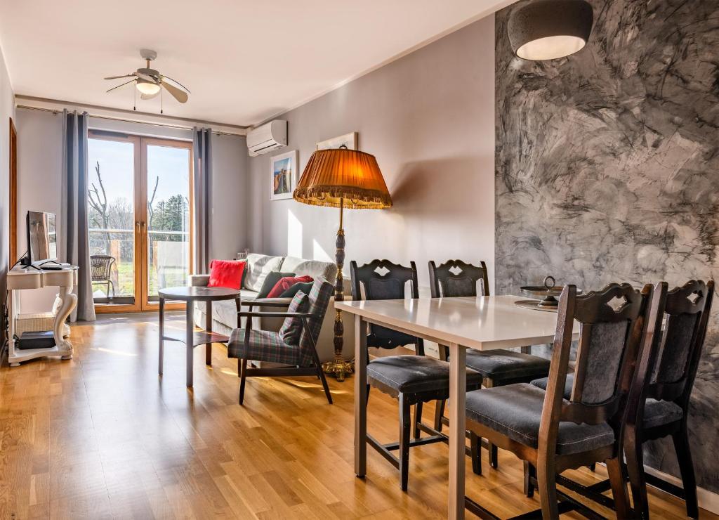 a dining room with a table and chairs at Apartament Stonehaven in Jastrzębia Góra