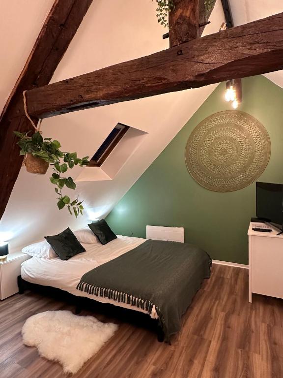 une chambre avec un lit et un mur végétal dans l'établissement Le Nid Douillet - Hypercentre - Studio, à Beauvais
