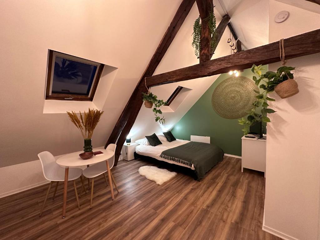 a bedroom with a bed and a table in a room at Le Nid Douillet - Hypercentre - Studio in Beauvais