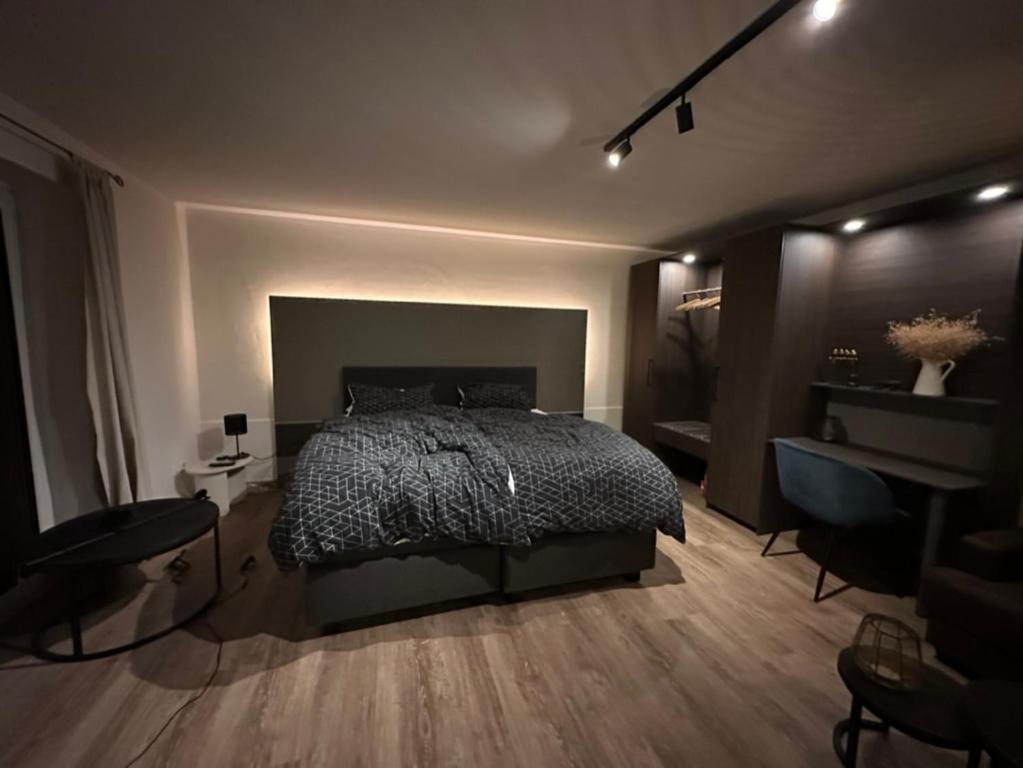 Schlafzimmer mit einem Bett, einem Tisch und einem Schreibtisch in der Unterkunft Apartment Hideaway in Bad Oeynhausen