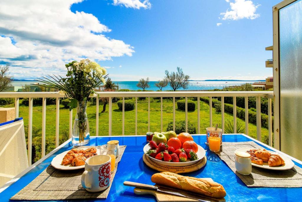 une table bleue avec de la nourriture au-dessus d'un balcon dans l'établissement SELECT'soHOME - Studio pour 2 personnes sur la plage du Lavandou avec parking privé ! - FREGATE-04, au Lavandou