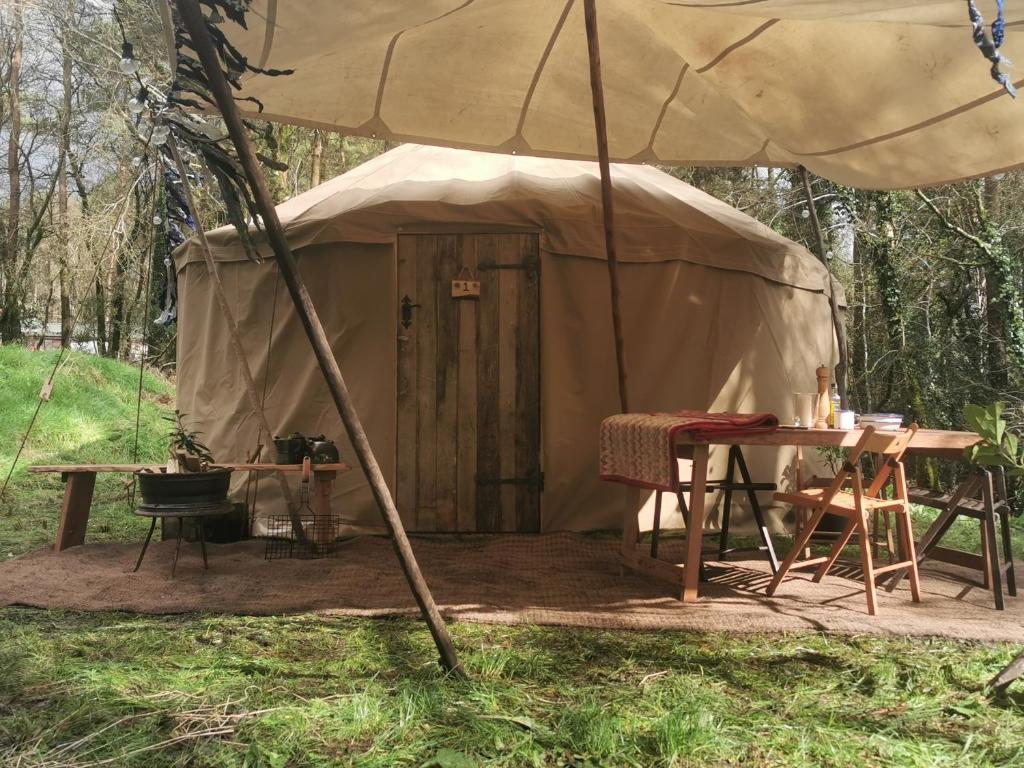 a yurt with a table and a table and chairs at Sweet Hill Eco Fort in Exeter