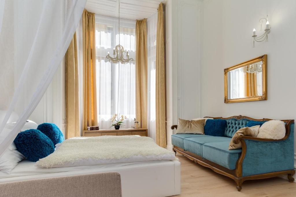 ein Wohnzimmer mit einem blauen Sofa und einem Bett in der Unterkunft Bella DeLux Apartment in Budapest