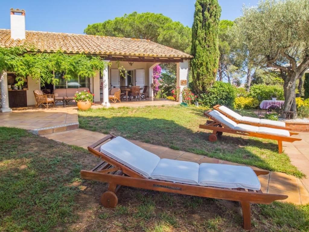 a yard with two lounge chairs and a house at Villa colette in Sant Antoni de Calonge