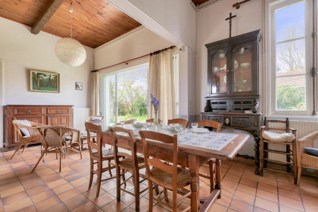 uma sala de jantar com mesa e cadeiras em Echappee familiale dans cette grande maison em Lanton