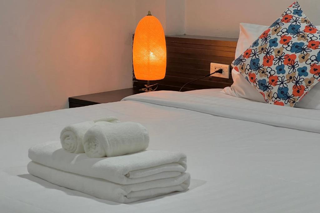 a hotel room with towels on a bed at De Nawarat Chiangmai Boutique Apartment in Chiang Mai