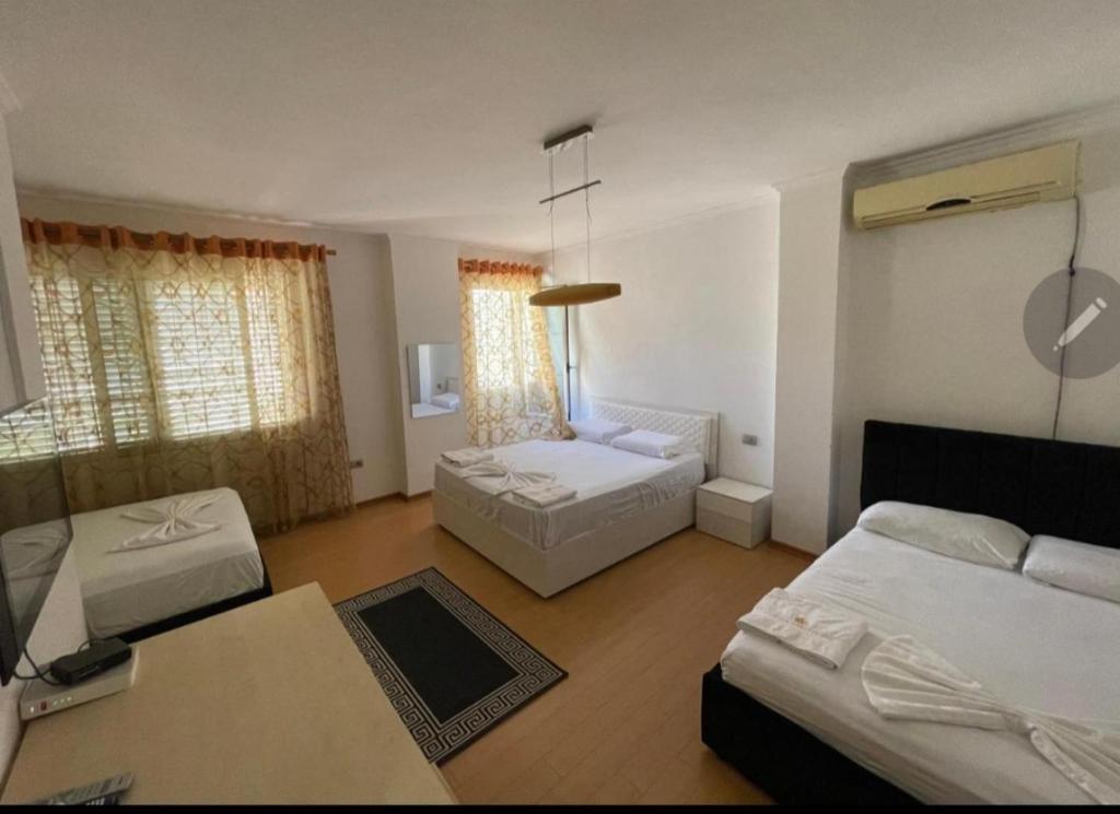 uma sala de estar com duas camas e um sofá em ALBJONA GUESTHOUSE TIRANA em Tirana