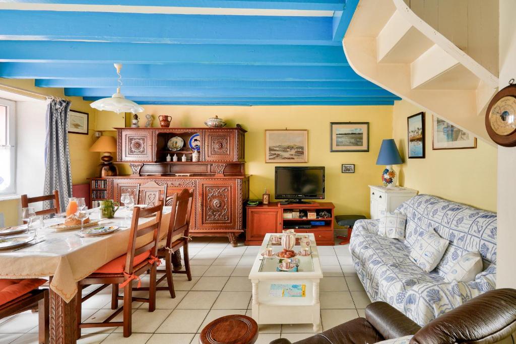 ein Wohnzimmer mit einem Tisch und einem Sofa in der Unterkunft Vacances en famille à Ile-Tudy in Île-Tudy