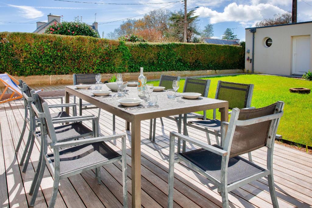 une table et des chaises en bois sur une terrasse dans l'établissement 850 m plage la 