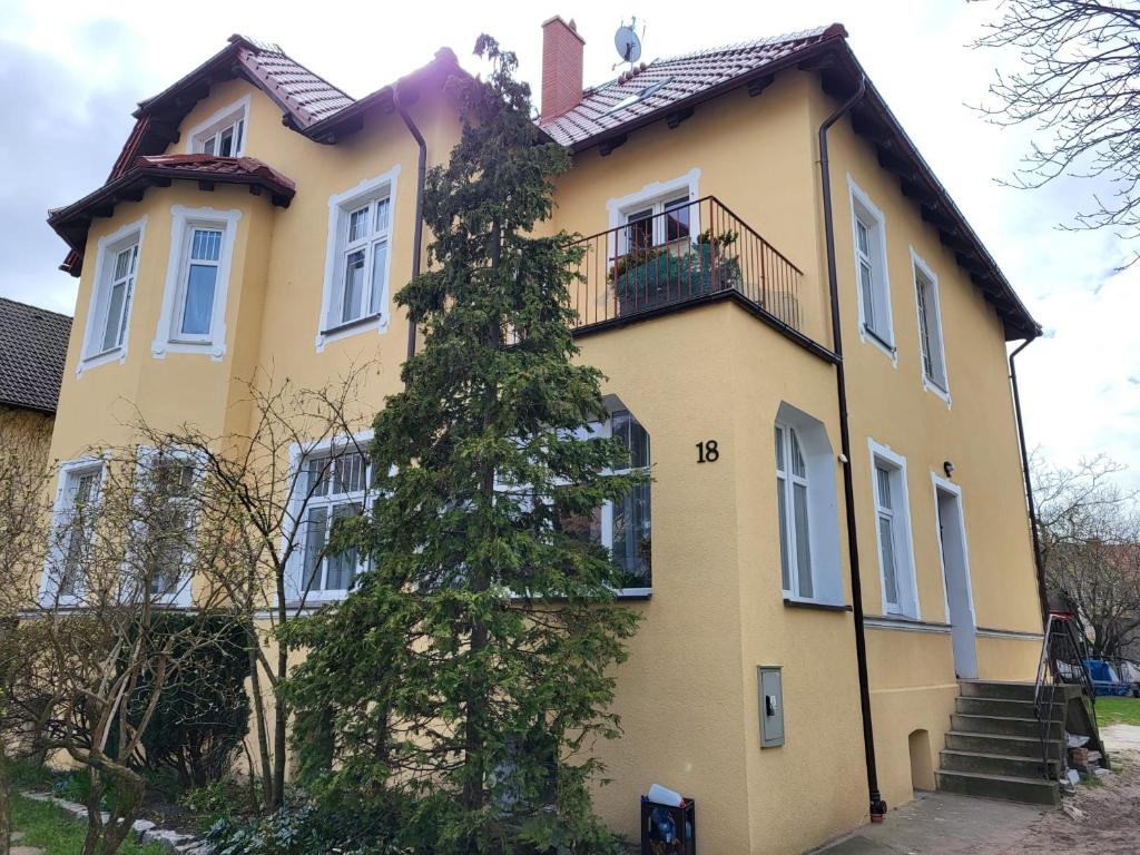 ウストカにあるSpokojna Przystanの木の前の黄色い家