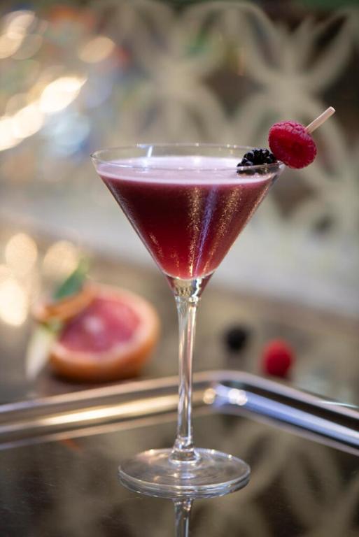 una bevanda rossa in un bicchiere di Martini con un lampone di Hotel Le Parc a Wiener Neustadt