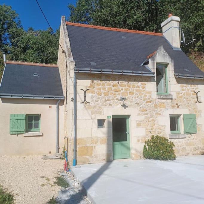 - un petit bâtiment en pierre avec une porte verte dans l'établissement Maison en lisière de forêt, à Panzoult
