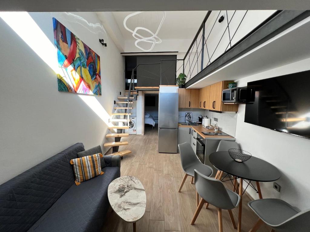 Il comprend un salon et une cuisine avec un canapé et une table. dans l'établissement City Center Loft, à Kavala