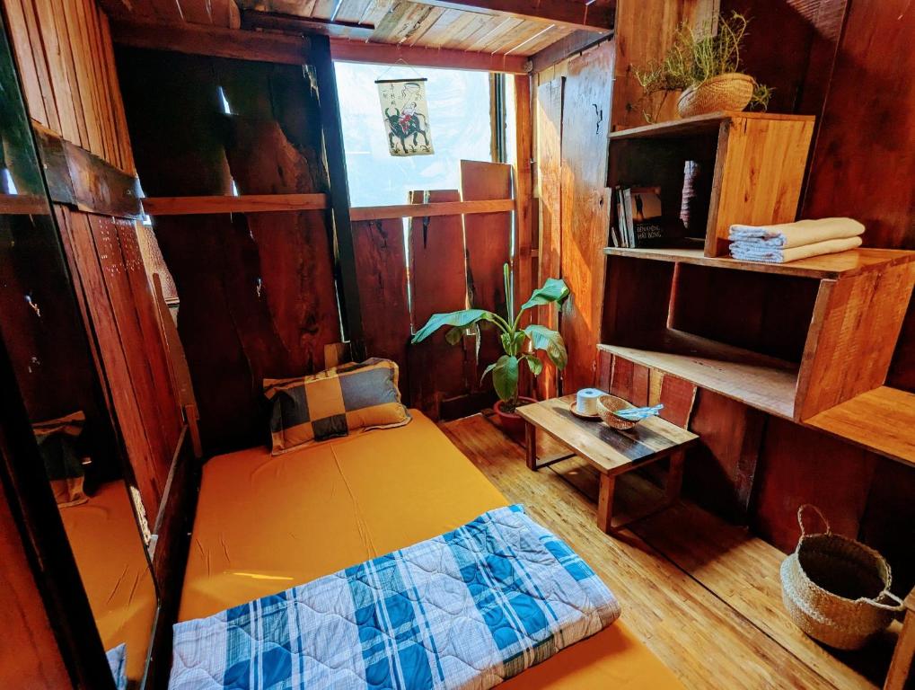 Cette petite chambre comprend un lit et une table. dans l'établissement The GK House Hostel, Ecolliving, central city, natural wooden, chill view rooftop, reétaurant and cocktail bar, à Hô-Chi-Minh-Ville