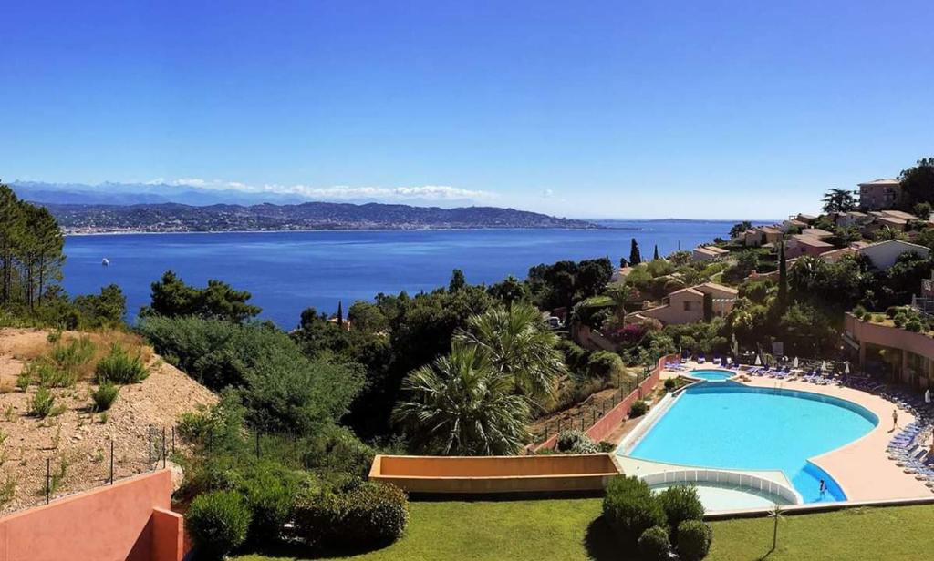a resort with a swimming pool and a view of the water at Rousseau in Théoule-sur-Mer