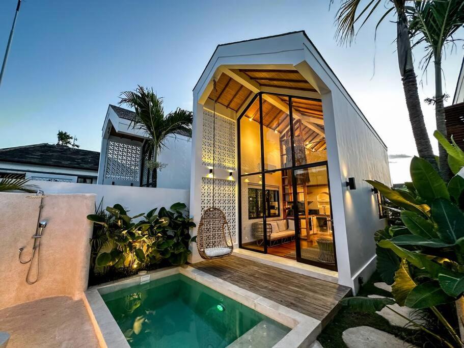 uma casa com piscina e uma casa em The Putih Tiny Villa - Architectural House 4 mins from Beach em Tanah Lot