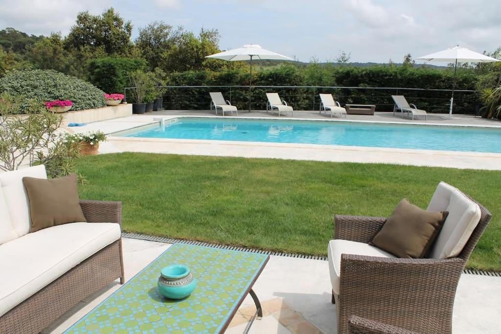 - une piscine avec des chaises et une table à côté d'une cour dans l'établissement Villa de plein pied pour 8 personnes à Gassin, à Saint-Tropez