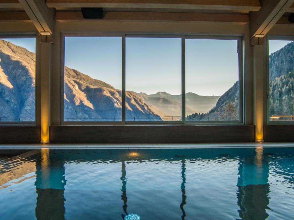 uma casa com piscina com montanhas ao fundo em Belvedere Hotel em Crodo