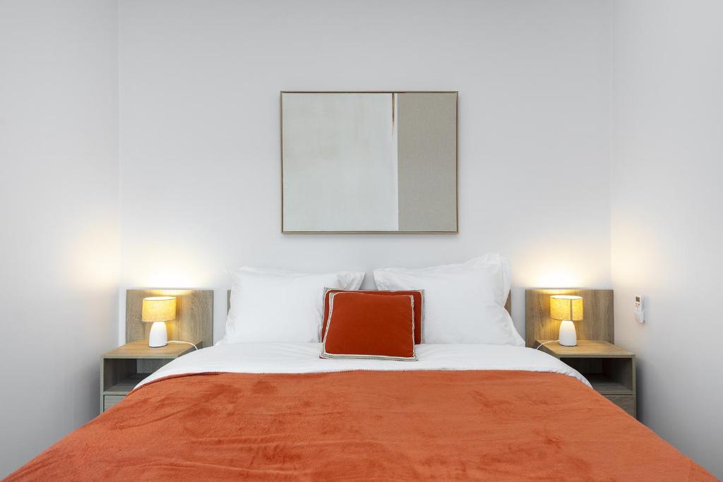 a bed with a red pillow on top of it at Cozy Apt in Lisbon with Terrace by Soulplaces in Lisbon