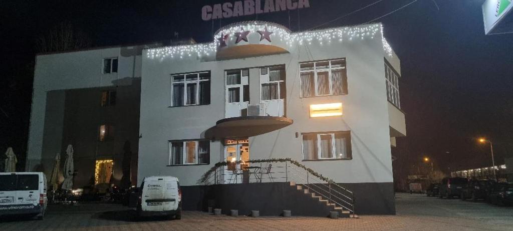 a large white building with lights on it at night at CASABLANCA in Craiova