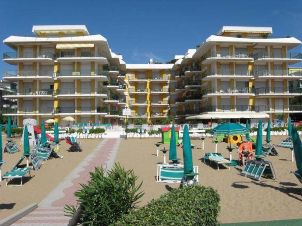 una playa con sillas y sombrillas y un hotel en Residence Il Panfilo sul Mare, en Lido di Jesolo