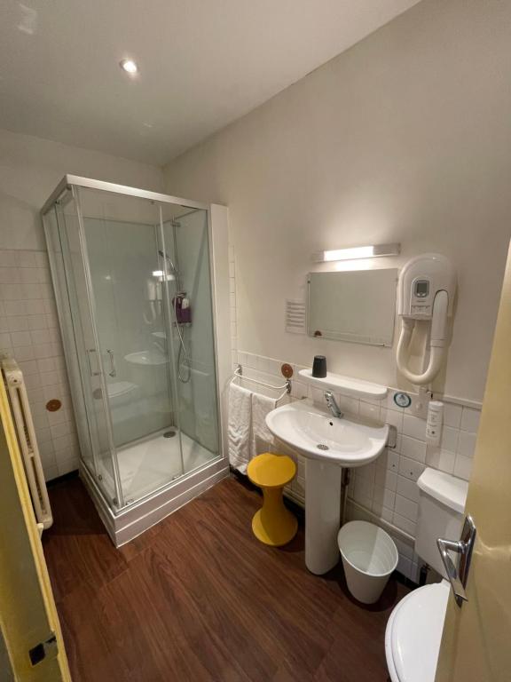 La salle de bains est pourvue d&#39;une douche et d&#39;un lavabo. dans l&#39;établissement Hôtel de Verdun, à Nevers