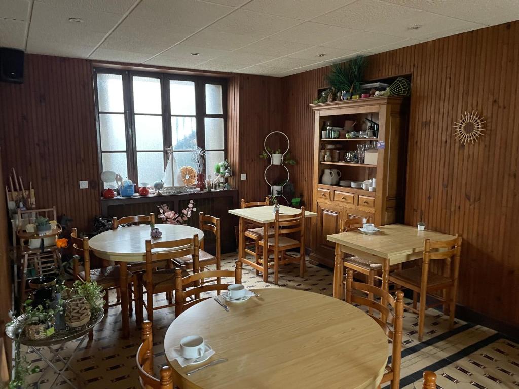 une salle à manger avec des tables et des chaises en bois dans l&#39;établissement Hôtel de Verdun, à Nevers