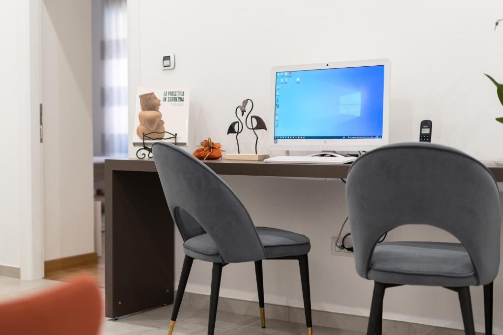 two chairs sitting in front of a desk with a computer at L'isola che c'è - Appartamento in Cagliari