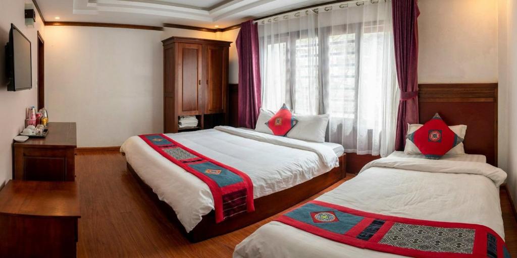 een hotelkamer met 2 bedden en een raam bij HƯƠNG GIANG HOTEL in Sa Pa
